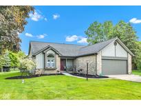 Charming home featuring a well-maintained lawn, stone accents, and an attached two-car garage at 206 Cranberry Dr, Greenfield, IN 46140