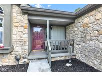 Inviting front porch with stone facade, seating area, and a decorative door at 206 Cranberry Dr, Greenfield, IN 46140