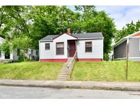 Charming small home with white siding, red trim, concrete steps, and a grassy front yard at 2966 N Olney St, Indianapolis, IN 46218