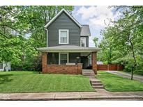 Charming two-story home featuring a welcoming front porch with a porch swing, landscaped yard, and classic architectural details at 31 N Bolton Ave, Indianapolis, IN 46219