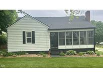Charming home featuring a lovely screened-in porch, manicured lawn, and appealing front yard landscaping at 3324 S Walnut St, Muncie, IN 47302