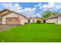 Charming brick home with a well-maintained lawn and attached garage, complemented by an American flag at 3537 Woodglen Way, Anderson, IN 46011