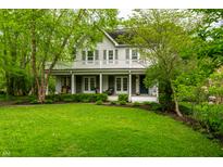 Beautiful two-story home featuring a spacious porch and a lush, green lawn at 4130 N Meridian St, Indianapolis, IN 46208