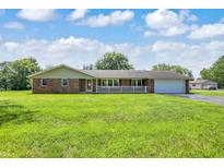 Charming brick ranch with a large front yard, attached two car garage, and a covered front porch at 4197 E 250 S, Franklin, IN 46131