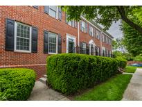 Brick townhouse with black shutters, manicured bushes and a sidewalk in front of the homes at 4332 Heyward Pl, Indianapolis, IN 46250