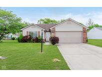 Charming single-story home with a well-manicured lawn and attached two-car garage at 5083 Emmert Dr, Indianapolis, IN 46221