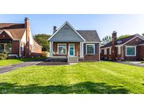 Charming brick home with a cozy front porch and a well-manicured lawn at 5428 E 10Th St, Indianapolis, IN 46219