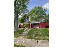 Cozy single-story red home featuring a covered porch and a classic design at 5802 Bertha St, Indianapolis, IN 46241
