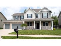 Charming two-story home featuring a welcoming front porch, well-manicured lawn, and a two-car garage at 5824 W Commonview Dr, McCordsville, IN 46055