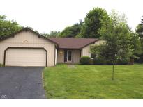 Charming single-story home with a well-maintained front lawn, attached garage, and beautiful landscaping at 60 Bittersweet Ct, Noblesville, IN 46062