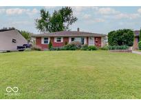 Charming brick home featuring a lush front lawn and manicured landscaping at 6069 E 15Th St, Indianapolis, IN 46219