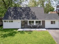 Charming Cape Cod-style home with a manicured lawn and a cozy front porch seating area at 6143 E 43Rd St, Indianapolis, IN 46226