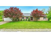 Charming brick home with well-manicured lawn, mature trees, and an attached two-car garage at 6462 Wings Ct, Brownsburg, IN 46112