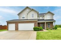 Charming two-story home featuring a two-car garage, brick and siding exterior, and a well-manicured lawn at 7604 Cloudy Ct, Camby, IN 46113