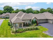 Well-maintained home featuring a beautiful landscaped front yard, charming shrubbery, and an attached three-car garage at 7645 Briarstone Ln, Indianapolis, IN 46227