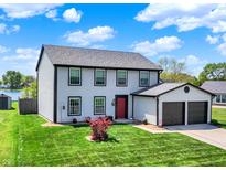 Charming two-story home features a red front door, attached two-car garage and well-manicured lawn at 7670 Lippincott Way, Indianapolis, IN 46268