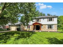 Two-story home with stone facade, attached garage, mature trees, and manicured lawn at 781 Dayton Dr, Carmel, IN 46033