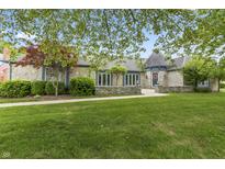 Charming stone home with turret entrance, manicured lawn, and inviting curb appeal at 8029 Castle Lake Rd, Indianapolis, IN 46256