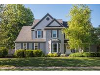 Charming two-story home with gray shutters and a well-manicured lawn, complemented by lush green trees at 107 W Columbine Ln, Westfield, IN 46074