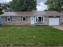 Charming brick home features a red roof, bay window, well-kept lawn, and an attached one car garage at 1280 Maple Ct, Martinsville, IN 46151