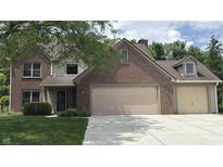 Charming two-story brick home featuring an attached two-car garage and a neatly manicured lawn at 14814 Beacon Blvd, Carmel, IN 46032