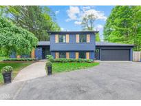 Eye-catching exterior of a blue house with charming wooden shutters and well-manicured landscaping at 1829 Kessler Blvd W Dr, Indianapolis, IN 46228