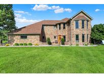 Charming two-story brick home with lush green lawn and well-maintained landscaping at 186 W 600 N, Alexandria, IN 46001