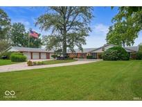 Charming ranch home with a large front lawn, mature trees, and an American flag flying high at 3000 E County Road 400 N, Muncie, IN 47303