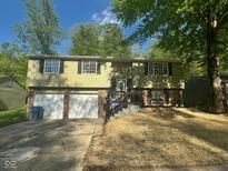 Charming two-story home features a welcoming front porch, an attached three-car garage and manicured front yard at 3541 Alpine Pl, Indianapolis, IN 46226