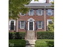 Charming brick townhome with classic blue shutters and meticulously maintained landscaping at 4024 Heyward Pl, Indianapolis, IN 46250