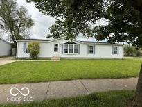 Charming single-story home with white siding, blue shutters, and manicured front lawn at 4617 Autumn Ridge Dr, Columbus, IN 47203