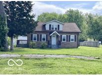 Charming home featuring a cozy front porch, complemented by mature trees and a well-maintained lawn at 4943 S State Ave, Indianapolis, IN 46227