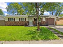 Charming ranch-style home with a brick accent, covered front porch, and well-manicured lawn at 5115 Bertha St, Indianapolis, IN 46241