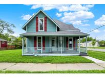 Charming two-story home featuring a covered front porch, red shutters, and a well-manicured lawn at 538 N East St, Greenfield, IN 46140