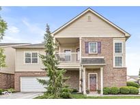 Charming two-story home featuring brick accents, a balcony, and a well-manicured front lawn at 5619 Payne Blvd, Plainfield, IN 46168