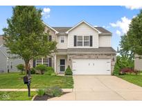 Charming two-story home with a well-manicured lawn and attached two-car garage at 7559 Pipestone Dr, Indianapolis, IN 46217