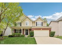 Charming two-story home featuring a well-manicured lawn, brick accents, and an attached two-car garage at 764 Bloor Woods Ct, Zionsville, IN 46077