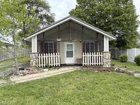 Charming home featuring a cozy front porch with stone accents and a white picket fence at 909 Sullivan St, Alexandria, IN 46001