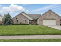 Charming brick home featuring a well-manicured lawn, lush greenery, and an attached two-car garage at 105 Meadowview Ln, Greenwood, IN 46142