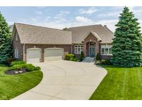 Charming brick home with a well-manicured lawn, mature trees, and an attached two-car garage at 10784 Giselle Way, Fishers, IN 46040