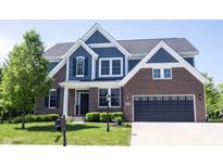 Beautiful two-story brick and blue home with a well-manicured lawn and attached two-car garage at 12600 Misty Ridge Ct, Fishers, IN 46037