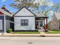 Charming home with a white exterior, black trim, and a cozy front porch area at 1837 S East St, Indianapolis, IN 46225
