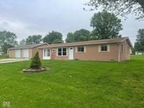 Charming single-story home with brick and tan siding, a well-maintained lawn, and a separate garage in the back at 2026 S Q St, Elwood, IN 46036
