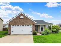 Charming single-story brick home with a well-manicured lawn, two-car garage, and inviting front porch at 2201 Schoolmarm Dr, Greenfield, IN 46140