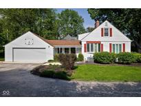 Charming home featuring a well-maintained lawn, red shuttered windows, and attached two car garage at 2929 E 62Nd St, Indianapolis, IN 46220
