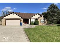 Charming home featuring a two-car garage, well-maintained lawn, and classic architectural details at 6143 Roberts Pl, Indianapolis, IN 46220