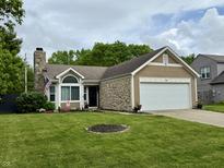 Charming one-story home boasts manicured lawn, stone accents, and an attached two-car garage at 9277 Embers Way, Indianapolis, IN 46250
