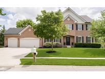 Charming brick two-story home with a well-manicured lawn, mature trees, and black shutters at 10144 Water Crest Dr, Fishers, IN 46038
