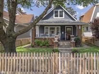 Charming two-story home with a cozy front porch, well-kept landscaping, and a classic picket fence at 1132 Evison St, Indianapolis, IN 46203
