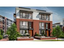 Beautiful three-story townhome featuring brick facade, large windows, and manicured landscaping with comfortable outdoor seating at 11940 Citywalk Dr, Fishers, IN 46038